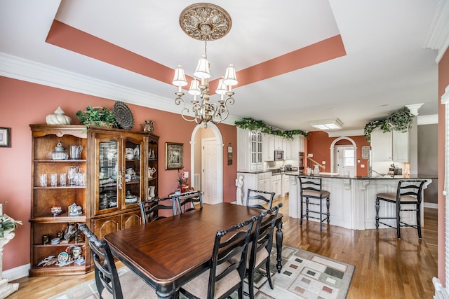 131 Grandview Cir, Gallatin, TN 37066 - dining space with arched walkways, a chandelier, light wood finished floors, baseboards, and ornamental molding