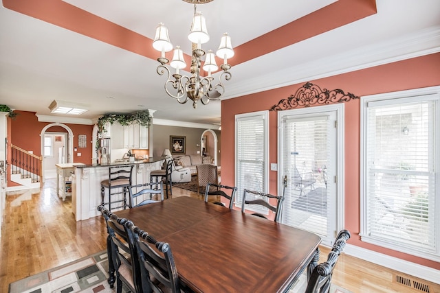 131 Grandview Cir, Gallatin, TN 37066 - dining room with ornamental molding, a chandelier, baseboards, light wood-style floors, and arched walkways