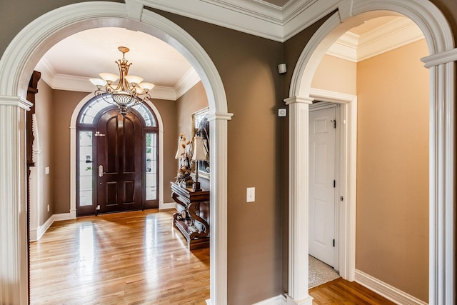 131 Grandview Cir, Gallatin, TN 37066 - foyer featuring arched walkways, a chandelier, light wood finished floors, ornamental molding, and ornate columns