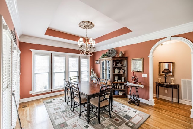 131 Grandview Cir, Gallatin, TN 37066 - dining area with a chandelier, baseboards, light wood finished floors, arched walkways, and crown molding