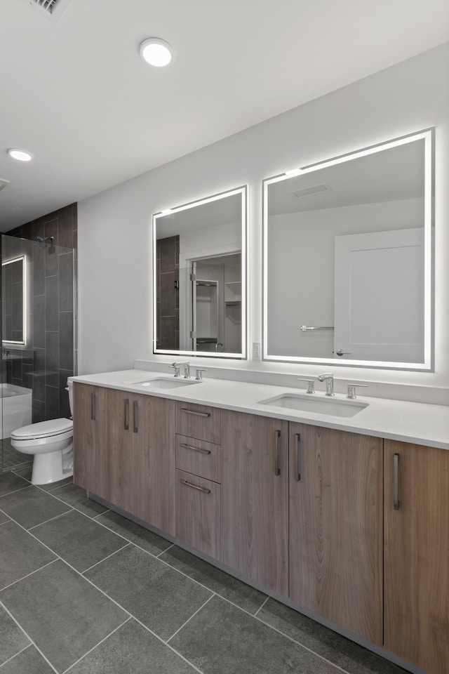 bathroom with tile patterned floors, a tile shower, toilet, double vanity, and recessed lighting
