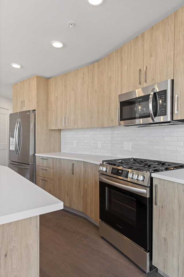 kitchen featuring stainless steel appliances, light brown cabinetry, modern cabinets, light countertops, and recessed lighting