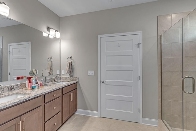 full bathroom featuring tile patterned floors, a shower stall, double vanity, and baseboards