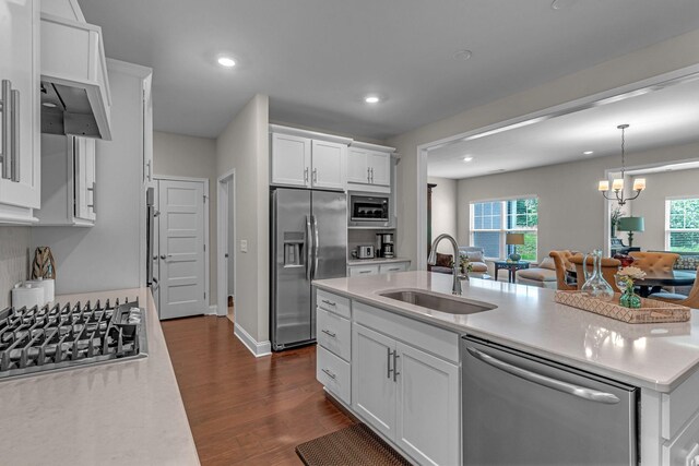 kitchen featuring stainless steel appliances, a sink, dark wood-style floors, light countertops, and white cabinets