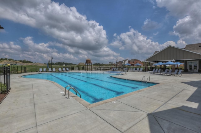 community pool featuring fence, a patio area, and french doors