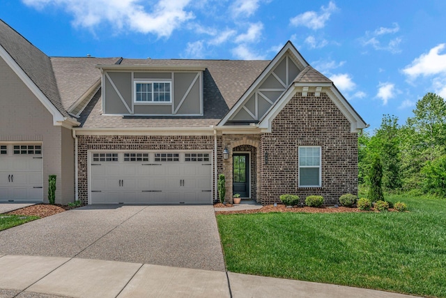 craftsman house with brick siding, driveway, a front lawn, roof with shingles, and an attached garage