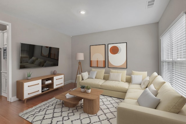 living room featuring light wood-type flooring, baseboards, and recessed lighting