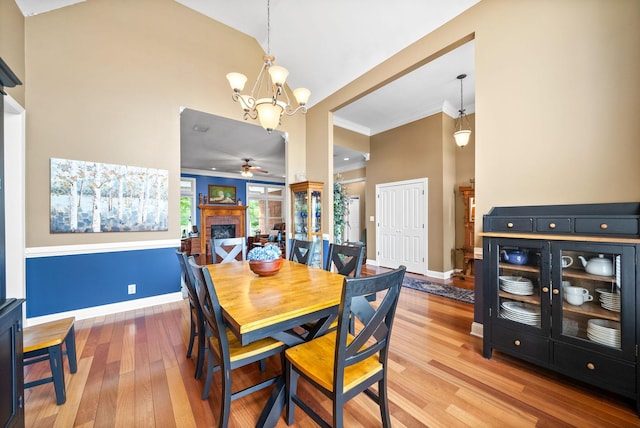 411 Lake Pointe Dr, Clarksville, TN 37043 - dining space featuring ceiling fan, a chandelier, light wood-style flooring, a high ceiling, and crown molding