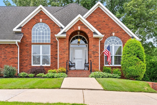 411 Lake Pointe Dr, Clarksville, TN 37043 - view of front facade featuring brick siding, roof with shingles, and a front lawn