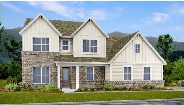 view of front of property featuring board and batten siding, brick siding, and a front lawn