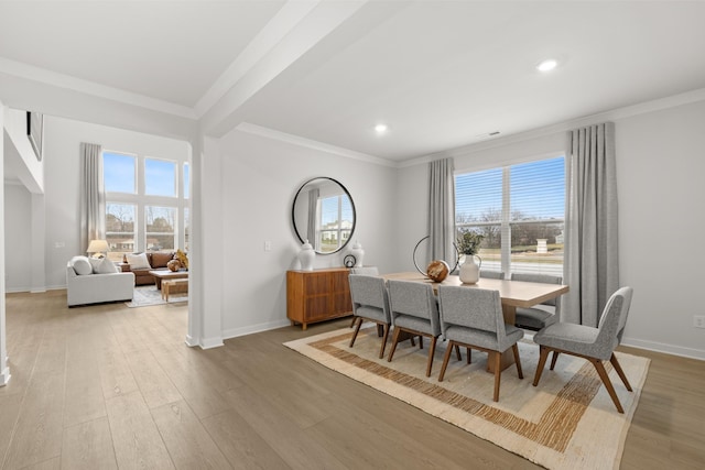 dining space with crown molding, light wood-style floors, baseboards, plenty of natural light, and recessed lighting