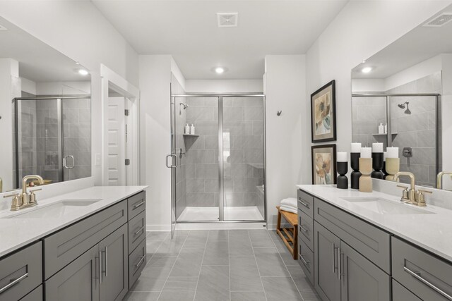 full bath with a stall shower, recessed lighting, two vanities, and tile patterned flooring