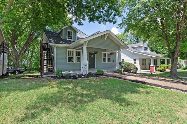 view of front facade with covered porch, stairway, and a front yard