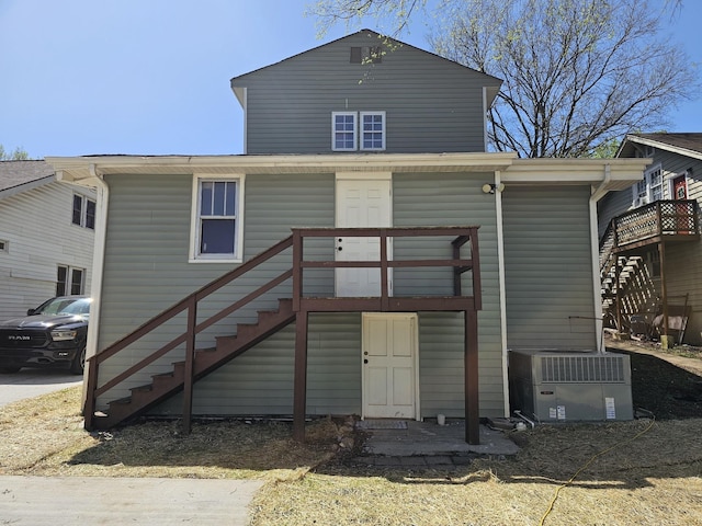 rear view of house featuring central air condition unit and stairs