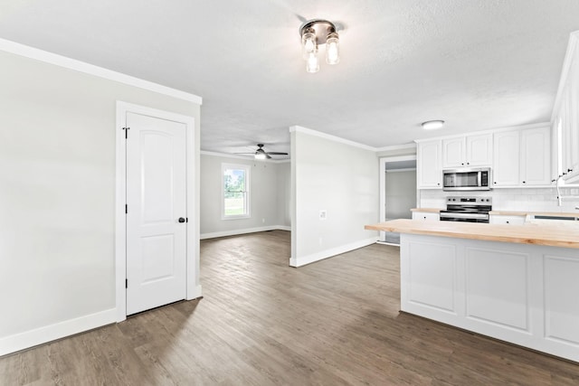 1950 Norton Rd, Lawrenceburg, TN 38464 - kitchen with appliances with stainless steel finishes, wood counters, baseboards, ornamental molding, and white cabinetry