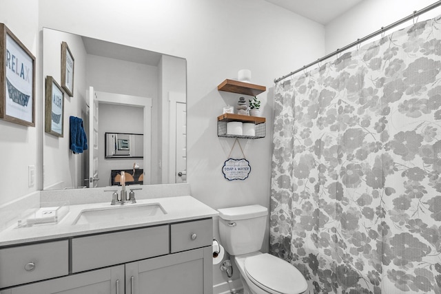 full bath with toilet, vanity, and a shower with shower curtain
