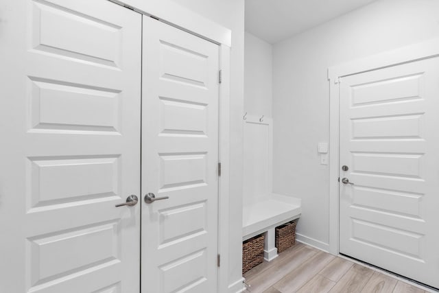 mudroom with light wood-style flooring and baseboards