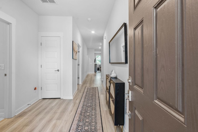 corridor featuring light wood-style floors, recessed lighting, and baseboards
