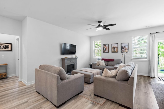 living area featuring a fireplace, plenty of natural light, and light wood-style floors