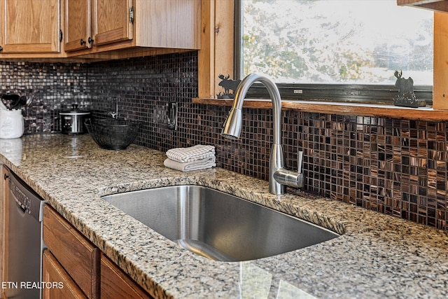 1640 Bench Mountain Way, Sevierville, TN 37862 - kitchen featuring a sink, stainless steel dishwasher, backsplash, brown cabinets, and light stone countertops