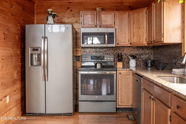 1640 Bench Mountain Way, Sevierville, TN 37862 - kitchen featuring stainless steel appliances, a sink, backsplash, light stone countertops, and light wood-style flooring