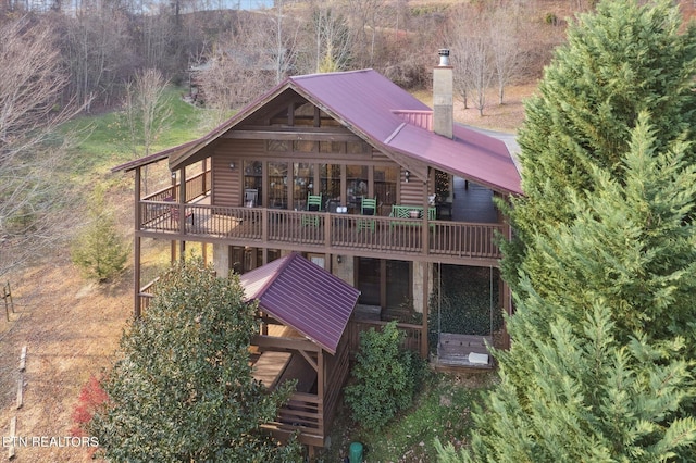 2409 Walnut Cove Way, Sevierville, TN 37862 - back of property with a chimney, metal roof, a deck, faux log siding, and a wooded view