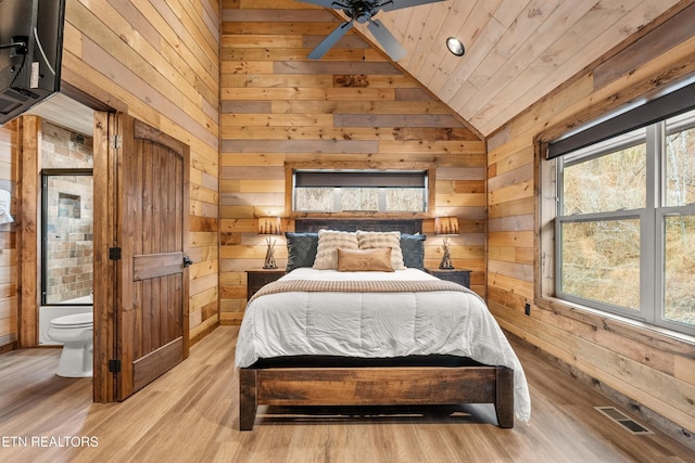 bedroom featuring vaulted ceiling, wood walls, light wood-type flooring, and wooden ceiling