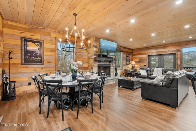 dining area with a chandelier, wooden walls, wood ceiling, light wood-style floors, and recessed lighting