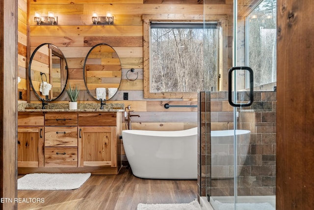 full bath with wood finished floors, wooden walls, a stall shower, healthy amount of natural light, and a soaking tub