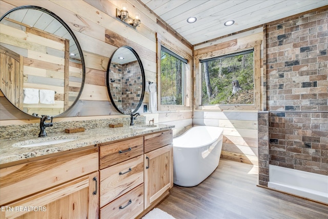 bathroom with a soaking tub, wood finished floors, double vanity, recessed lighting, and wood ceiling