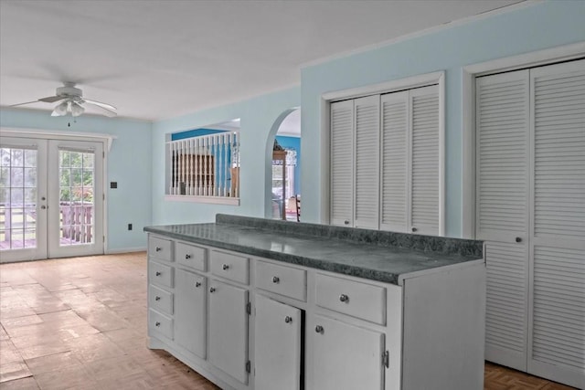 7158 Bahne Rd, Fairview, TN 37062 - kitchen featuring dark countertops, ceiling fan, arched walkways, white cabinetry, and french doors