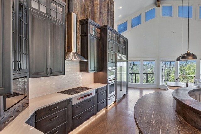 3910 Brick Church Pike, Nashville, TN 37207 - kitchen with a high ceiling, a warming drawer, backsplash, wall chimney range hood, and decorative light fixtures