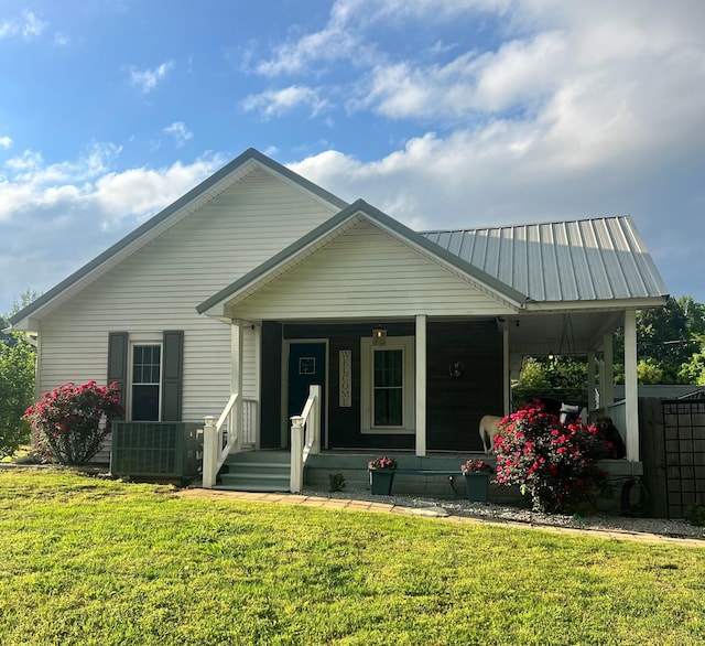 205 Park Ln, Hollow Rock, TN 38342 - view of front of home featuring central air condition unit, covered porch, a front lawn, and metal roof