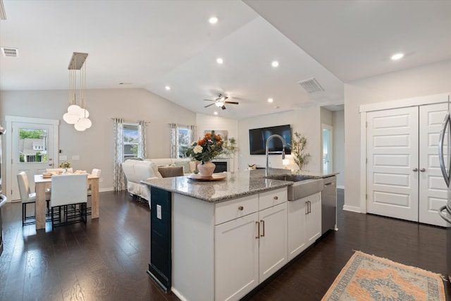 kitchen featuring a sink, lofted ceiling, stainless steel dishwasher, open floor plan, and ceiling fan