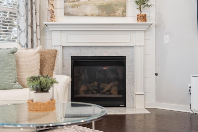 detailed view of a high end fireplace, wood finished floors, and baseboards