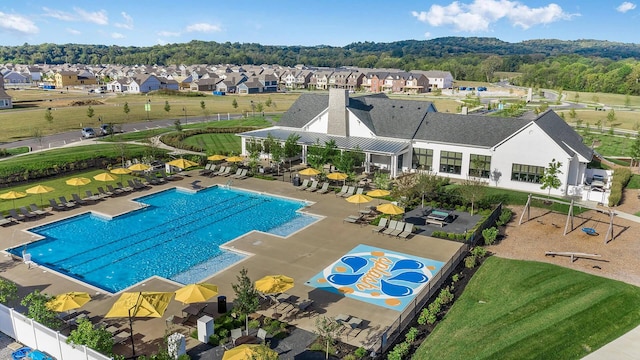 community pool featuring fence, a residential view, and a patio area