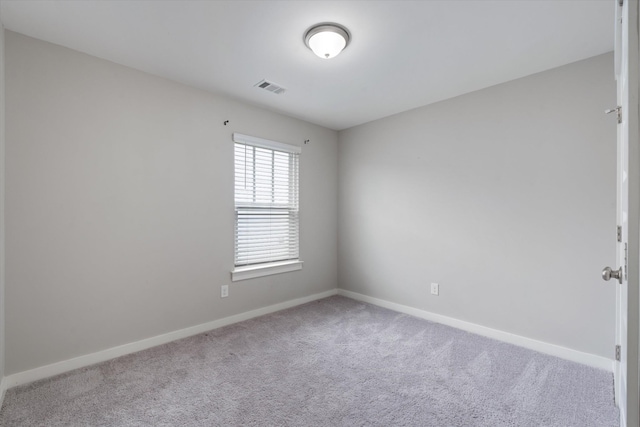 carpeted spare room featuring baseboards
