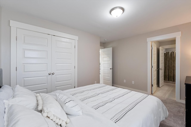 bedroom featuring a closet, light carpet, and baseboards