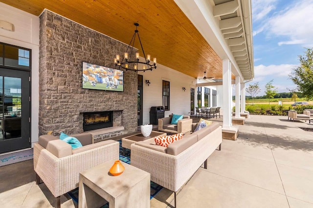 view of patio / terrace featuring an outdoor living space with a fireplace, outdoor dining space, and ceiling fan