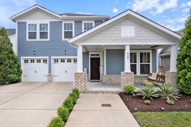 craftsman-style house with a porch, driveway, stone siding, and an attached garage