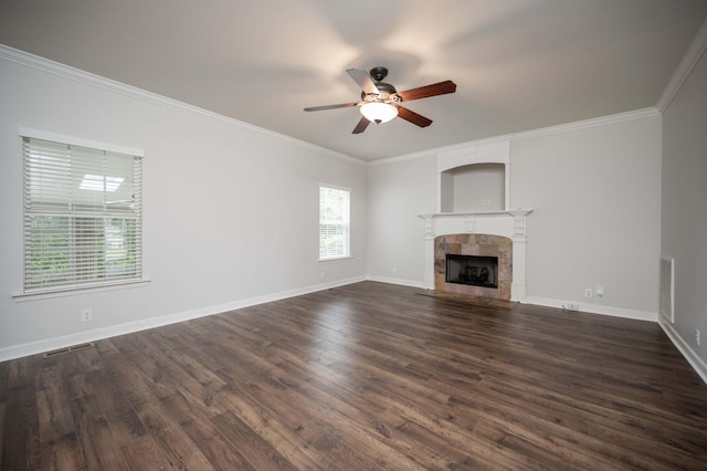 unfurnished living room featuring a ceiling fan, dark wood finished floors, a fireplace, ornamental molding, and baseboards