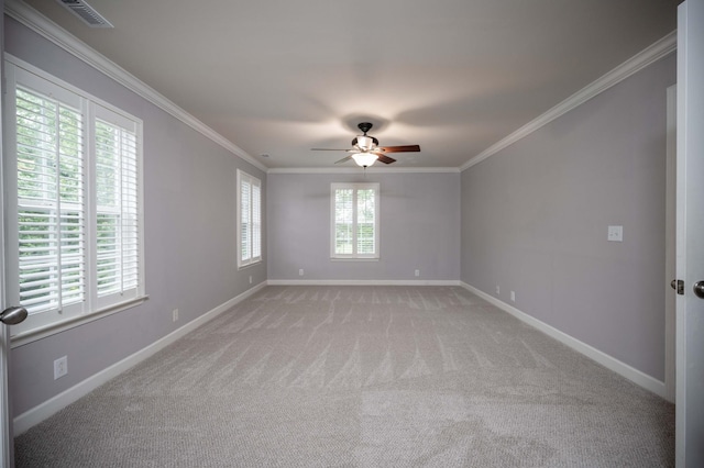 spare room with light colored carpet, ceiling fan, baseboards, and crown molding