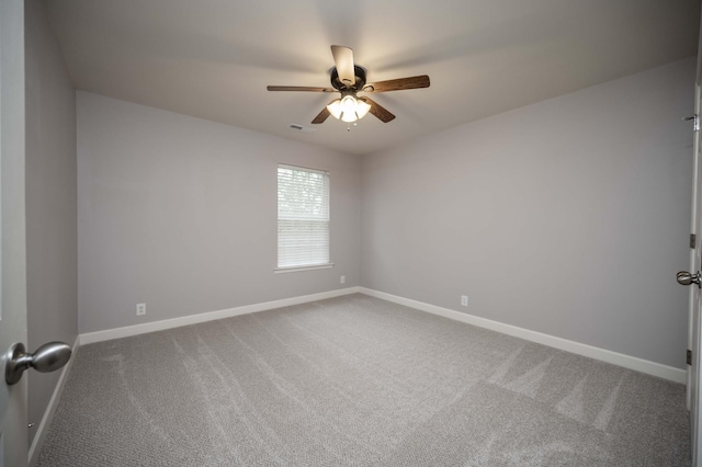 carpeted empty room with ceiling fan and baseboards