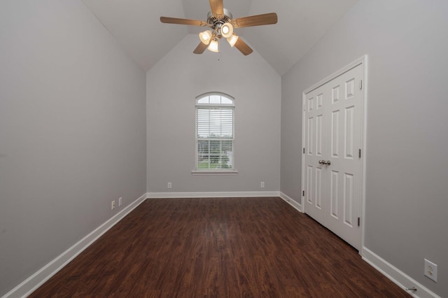 empty room with dark wood-style flooring, ceiling fan, baseboards, and vaulted ceiling