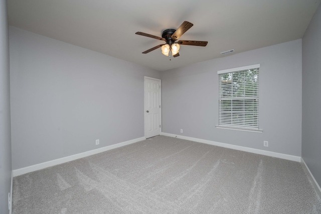 carpeted empty room featuring ceiling fan and baseboards