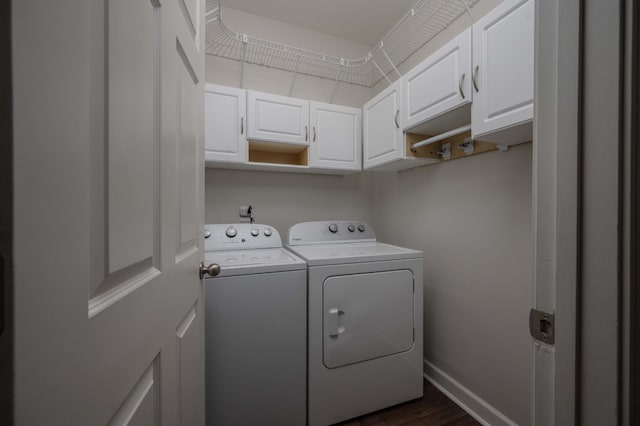 laundry room featuring separate washer and dryer, cabinet space, dark wood-style flooring, and baseboards