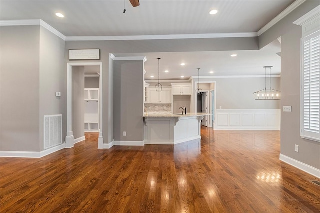 unfurnished living room featuring dark wood-type flooring, a sink, ceiling fan, recessed lighting, and crown molding