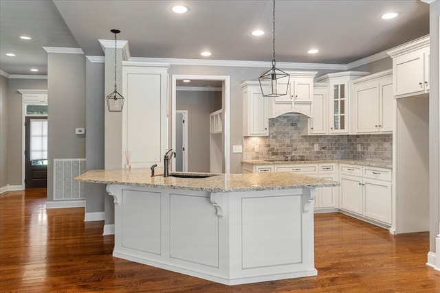 kitchen featuring crown molding, a sink, dark wood-style flooring, white cabinetry, and tasteful backsplash
