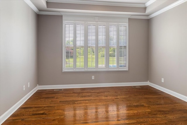 unfurnished room with crown molding, wood finished floors, and baseboards