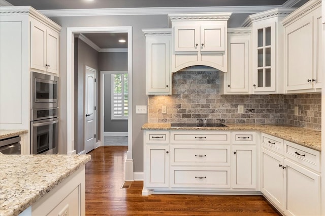 kitchen with stainless steel appliances, ornamental molding, dark wood-type flooring, baseboards, and backsplash